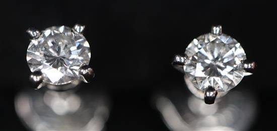 A pair of Cartier platinum set solitaire diamond ear studs, with Cartier box.